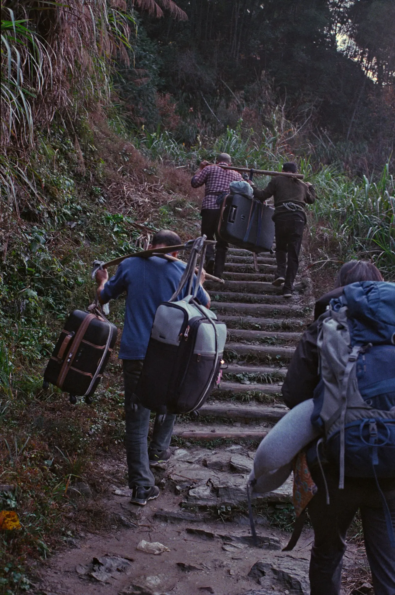 The locals help carry the crew's gear up the 800 steps to Mulihong village.