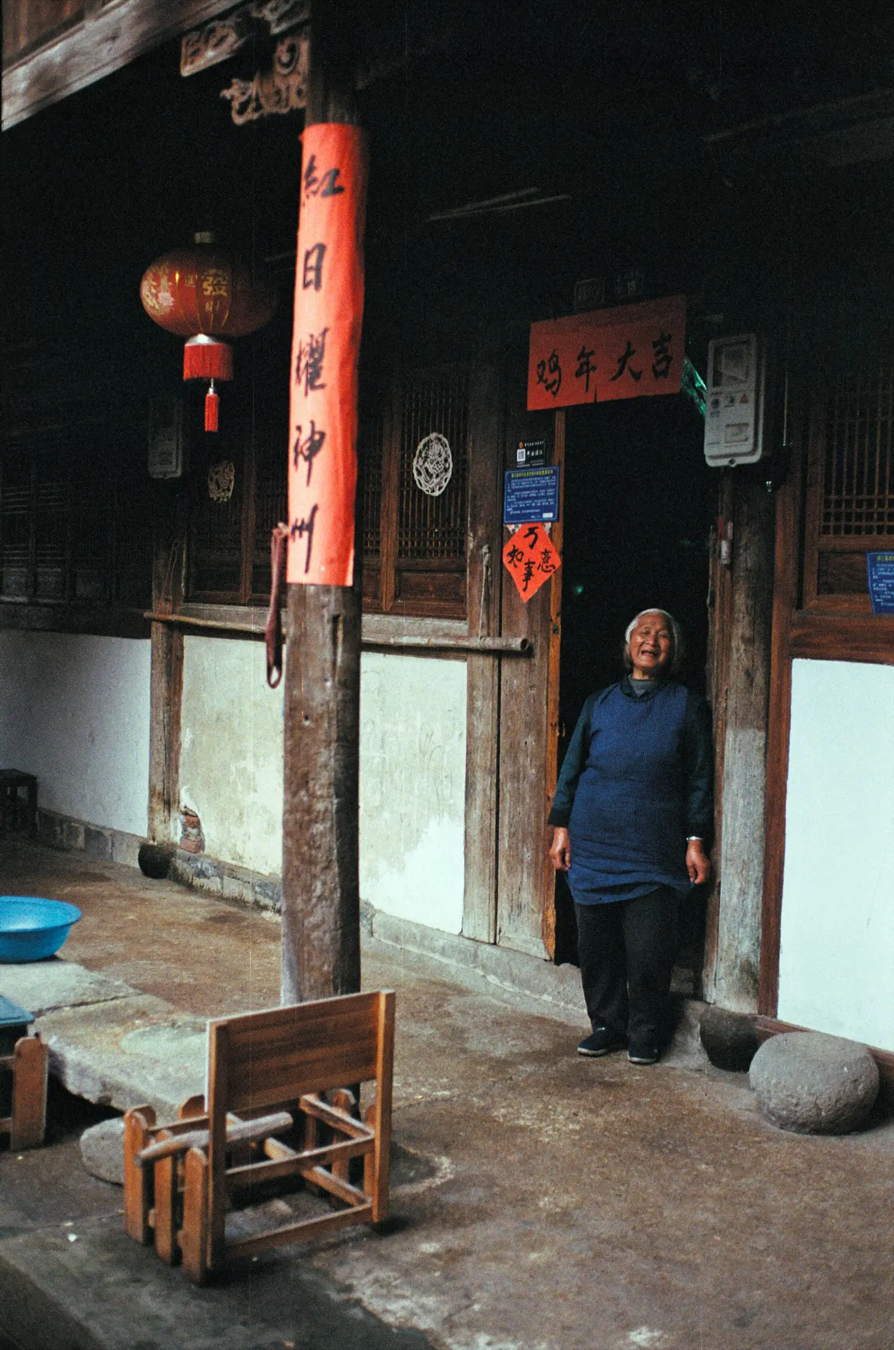 One of Chen-nainai's neighbours watches the film crew curiously from the front door of her house.