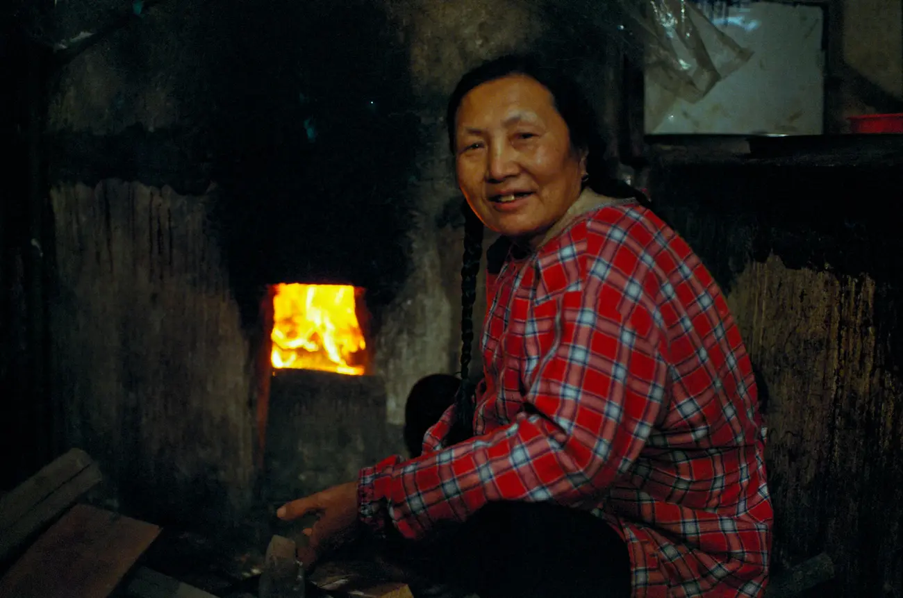 Granny Zhang tends to the fire for cooking the soya beans.