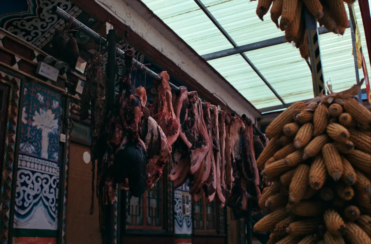 Meat and blood sausages drying on a rack to preserve.