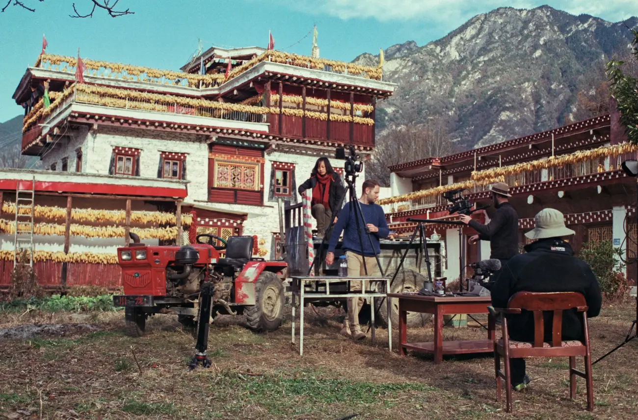The crew set up for a cooking scene in front of a guest house.