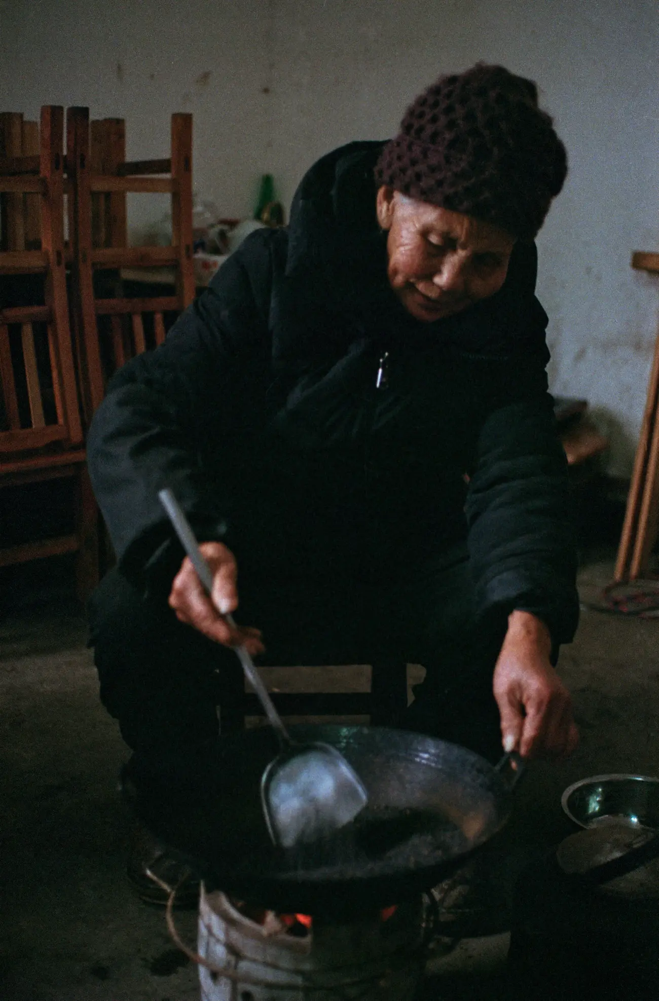 Nainai roasting sesame seeds on a coal stove.