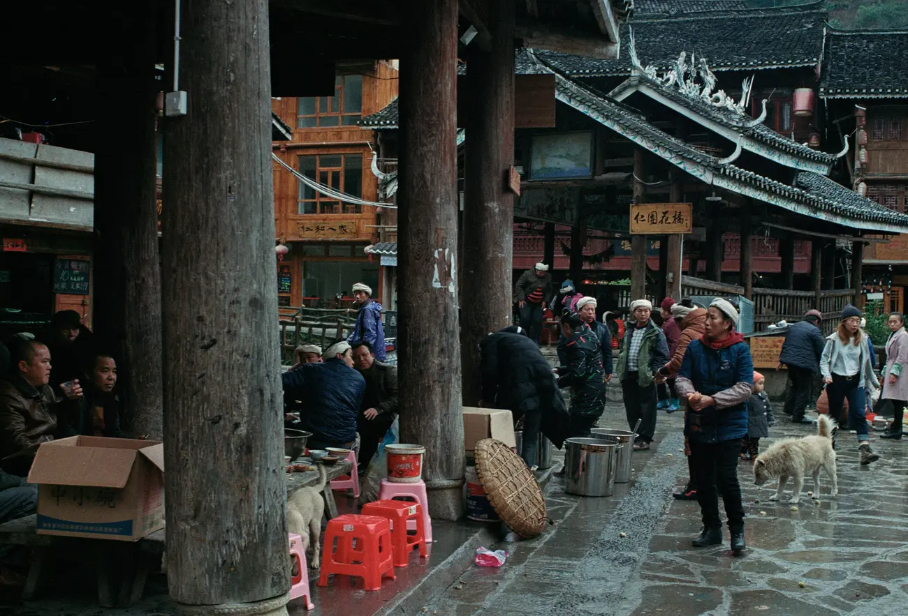 Locals hang out under drum towers in Zhaoxing village.